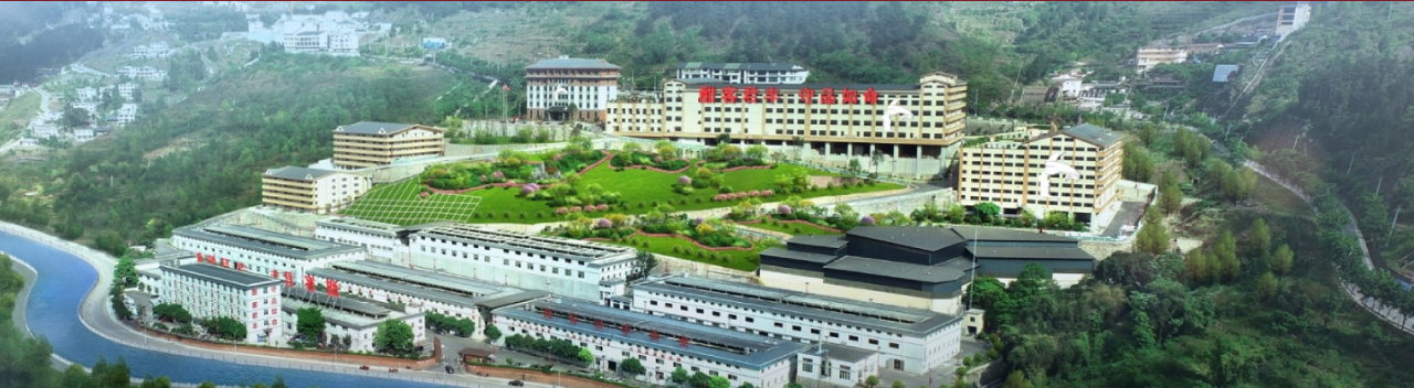 Vista publicada do complexo da destilaria HANKOL Junfeng junto a água e colinas verdes